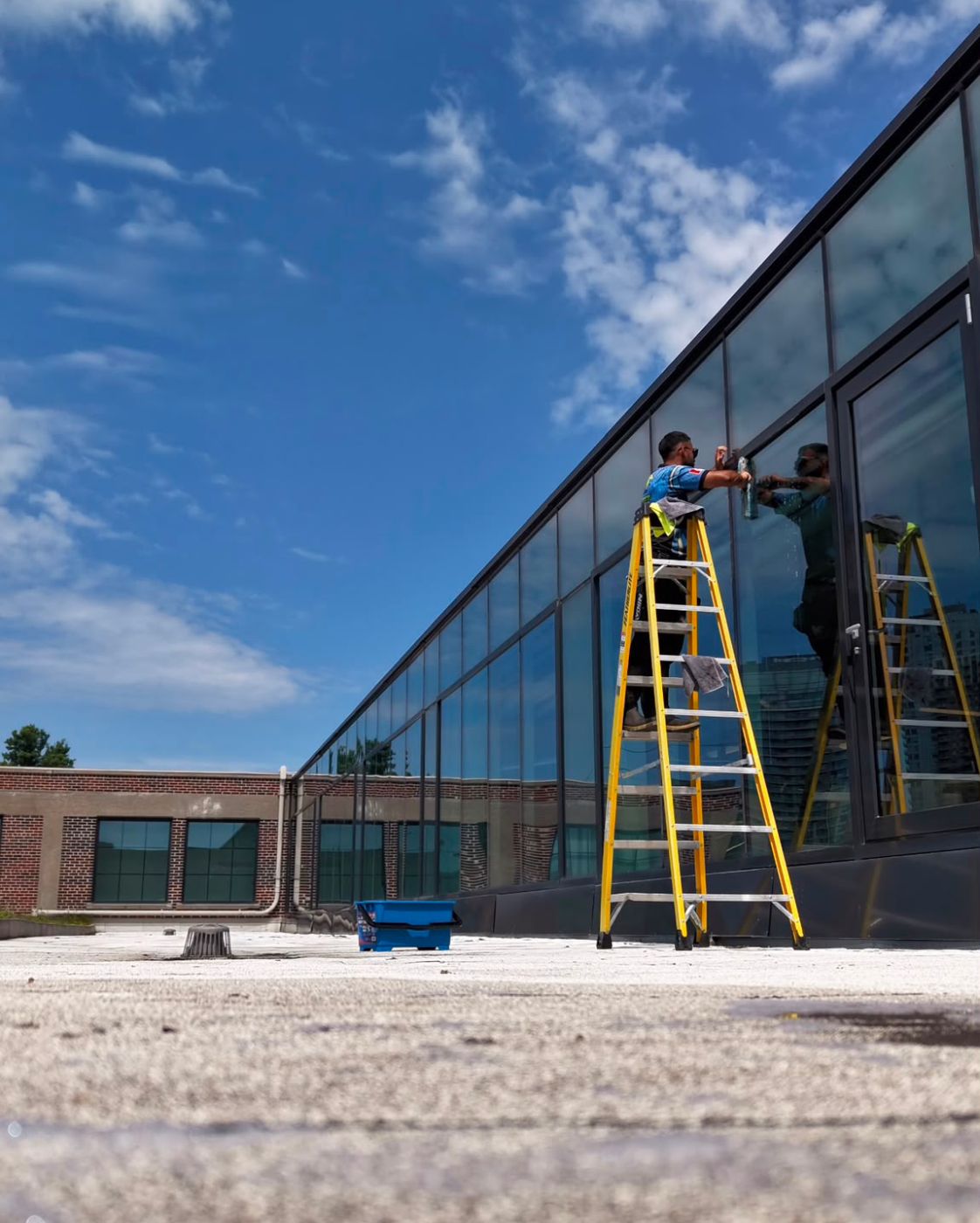 Wash Dudes technician cleaning commercial windows